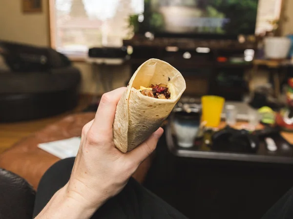 Segurando Burrito café da manhã na sala de estar — Fotografia de Stock