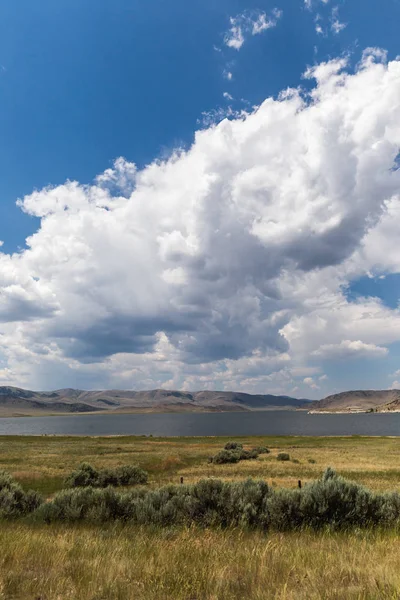 Nubes cúmulos y cielo azul sobre el lago — Foto de Stock