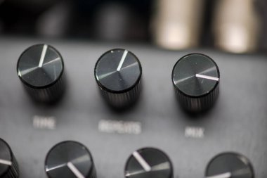 Gitarlar, sentezleyiciler ve diğer müzik aletleri için yapılmış bir donanım efekt pedalının tepesindeki kontrol düğmelerinin yakın plan detayları.
