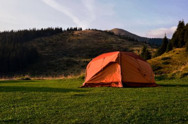 çadır günbatımı bakan dağlar ve bir vadi içinde