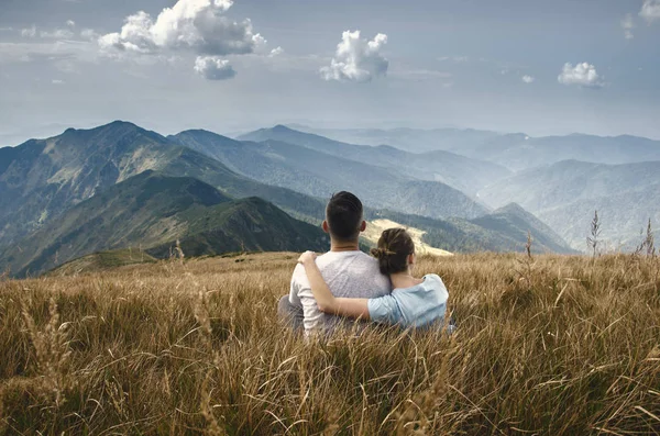 남자와 여 자가 산 꼭대기에 앉아 — 스톡 사진