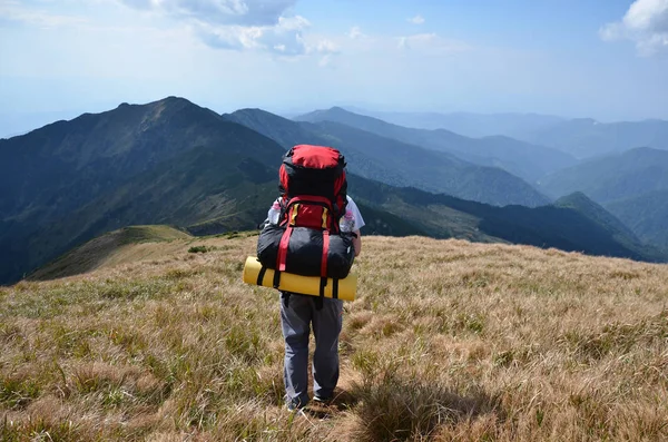 Turista con una mochila en las montañas — Foto de Stock