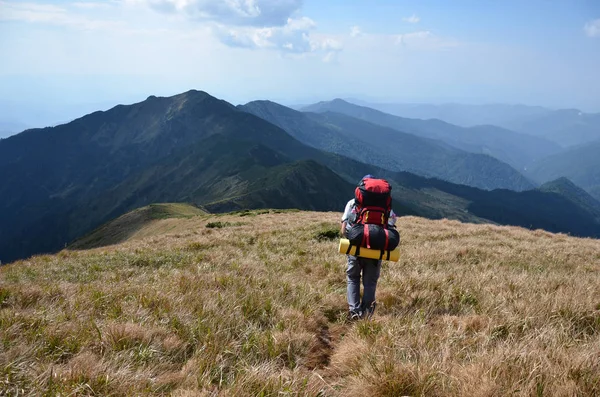 Turista con una mochila en las montañas — Foto de Stock