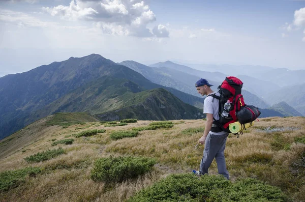 Turista con una mochila en las montañas — Foto de Stock