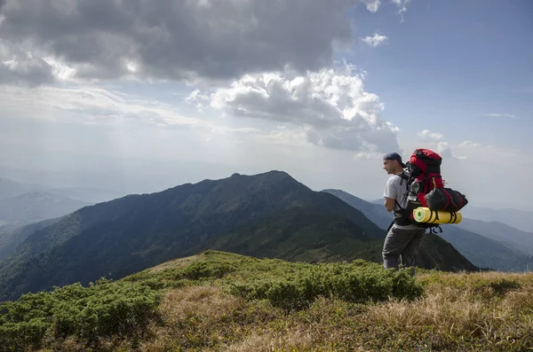 Turista con una mochila en las montañas — Foto de Stock