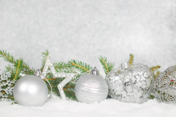 Bolas de Navidad y rama de abeto verde en la nieve — Foto de Stock