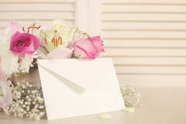 Mand van bloemen en envelop — Stockfoto