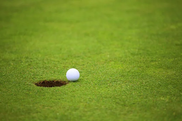 Golf ball op lip van cup — Stockfoto