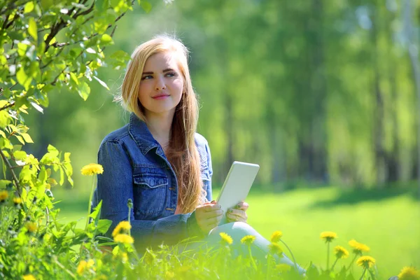 Young woman using tablet in park — Stock Photo, Image