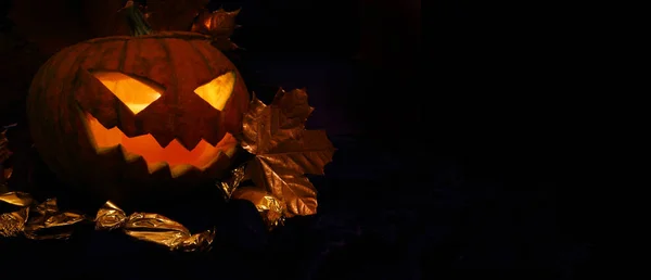 Abóbora de Halloween com folhas de outono em preto — Fotografia de Stock
