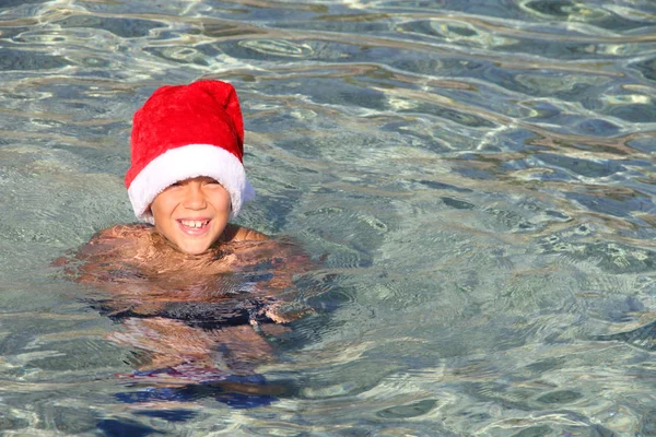 바다에서 산타 모자에 미소 소년 — 스톡 사진