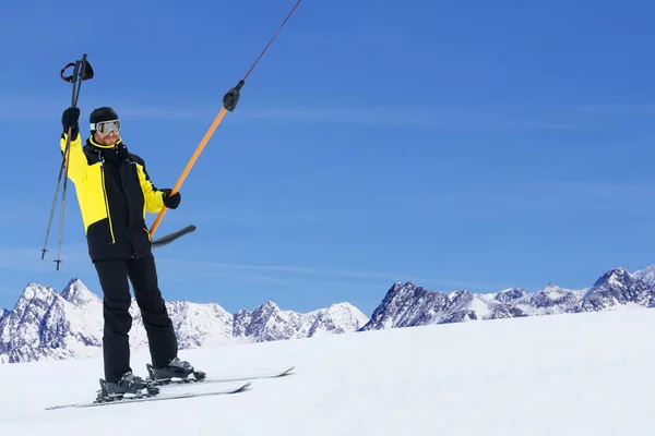 Happy skier using T-bar ski drag lift