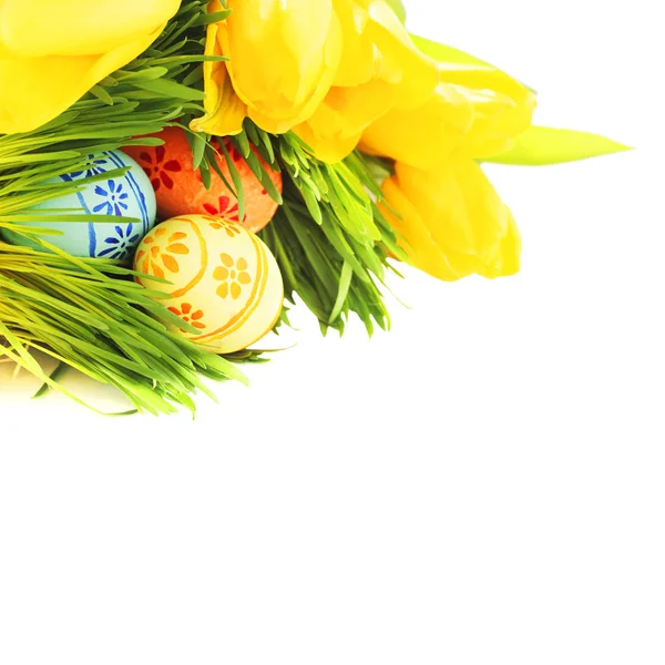 Easter eggs in grass with tulips — Stock Photo, Image