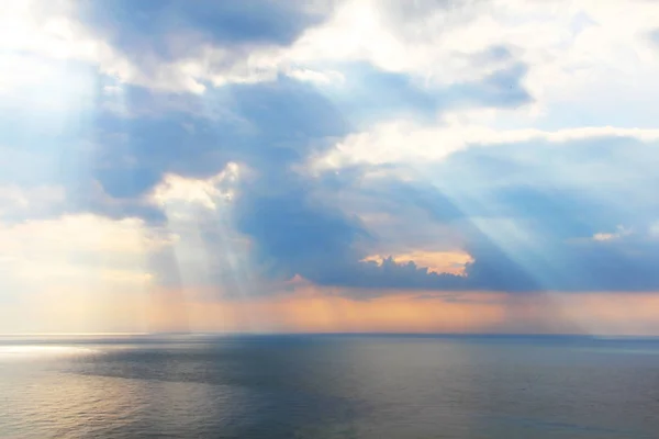 Lichtstrahlen durch die Wolken über dem Meer — Stockfoto