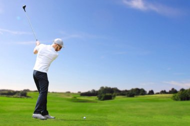 Golfçü bir golf topu vurmak