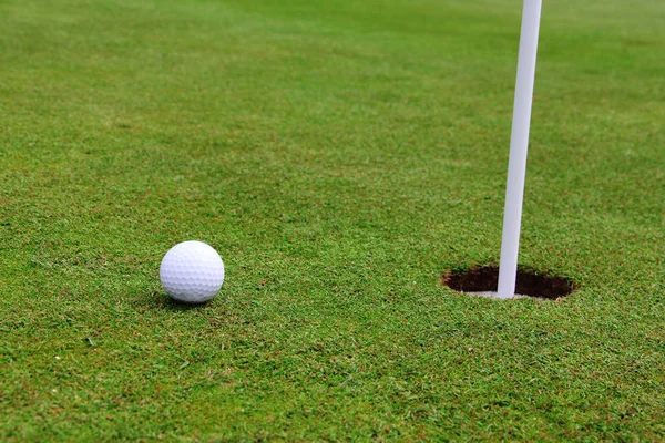 Golf ball op lip van cup — Stockfoto