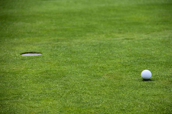 Balle de golf sur lèvre de tasse — Photo