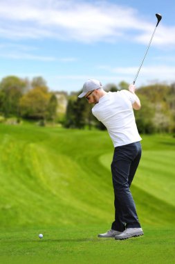 Golfçü bir golf topu vurmak