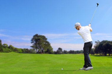 Golfçü bir golf topu vurmak