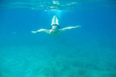 Adam suyun altında yüzüyor.