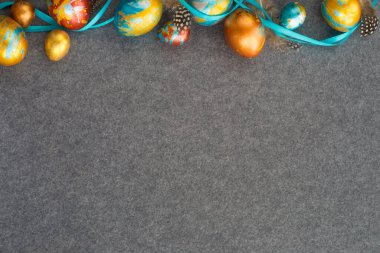 Gri tekstil arka planında el yapımı mükemmel paskalya yumurtaları, metin içeriği için fotokopi alanı ile kenar çerçeve şekli, mutlu paskalya kartı