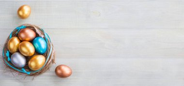 Güzel Paskalya bayramın kutlu olsun. Bayrağı renkli yumurtalarla ve kurdelelerle süsleyip açık tahta arka planda metin için fotokopi alanı oluşturarak kutla.