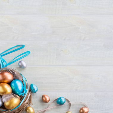 Güzel Paskalya bayramın kutlu olsun. Bayrağı renkli yumurtalarla ve kurdelelerle süsleyip açık tahta arka planda metin için fotokopi alanı oluşturarak kutla.