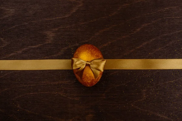 Złote Jajo Wielkanocne Wstążka Kompozycja Ciemnym Drewnianym Tle Miejsca Kopię — Zdjęcie stockowe