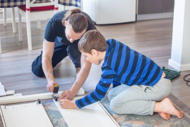 Aile ilişkileri, babalık, ebeveynlik, hobi, marangozluk, marangozluk konsepti - baba ve oğul evde birlikte mobilya yapıyorlar.