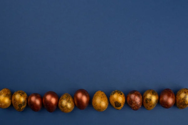 Маленькие Золотые Перепелиные Пасхальные Яйца Подряд Синем Фоне Скопировать Пространство — стоковое фото