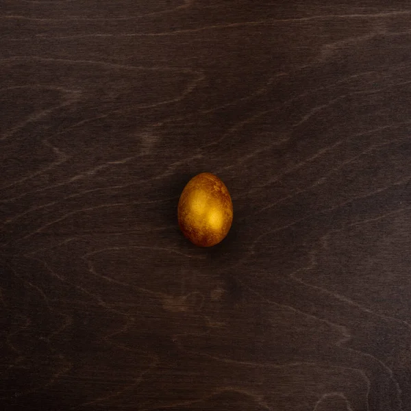 Jedno Velké Zlaté Velikonoční Vejce Tmavém Dřevěném Pozadí Kopírovat Prostor — Stock fotografie