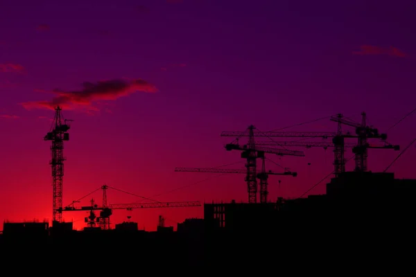 Stavební Jeřáby Domy Černá Silueta Nad Západem Slunce Obloha Mraky — Stock fotografie