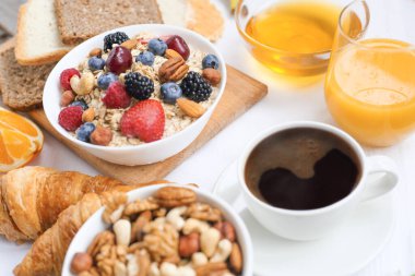 Müsli, meyve, böğürtlen, fındık, kahve, yumurta, bal, yulaf ve diğer yakın çekim ile sağlıklı bir kahvaltı.