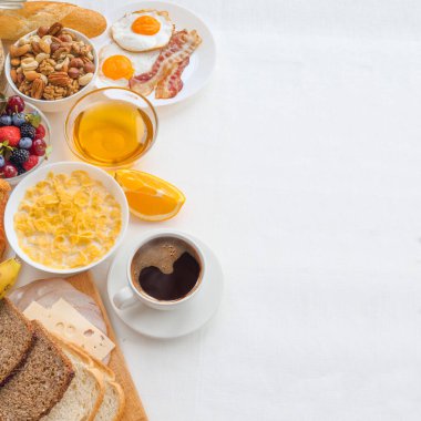 Müsli, meyve, böğürtlen, fındık, kahve, yumurta, bal, yulaf ve diğeriyle sağlıklı bir kahvaltı. Düz konum, üst görünüm, metin ve çerçeve için boşluk kopyala