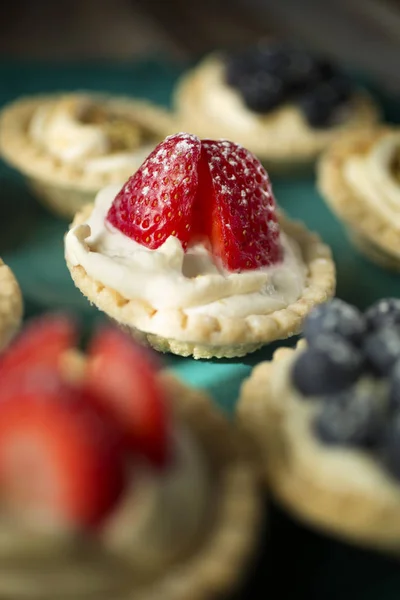 Strawberry tartlets on a green plate — Stock Photo, Image