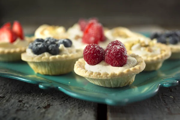 Berry tartlets on a green tray — Stock Photo, Image