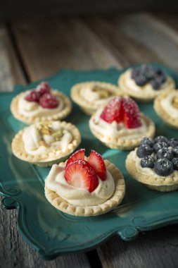 tartlets yeşil bir tabak içinde çilek ile
