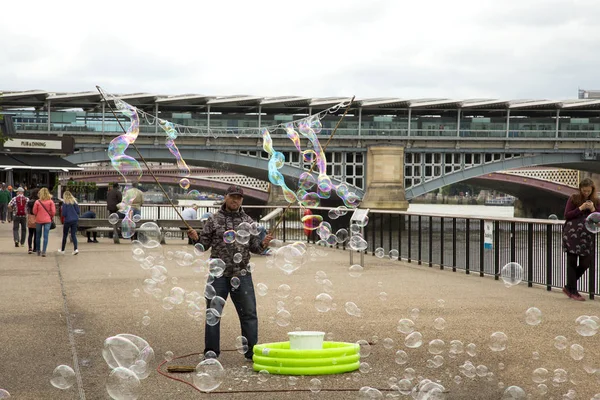 Hombre haciendo burbujas de jabón gigante — Foto de Stock