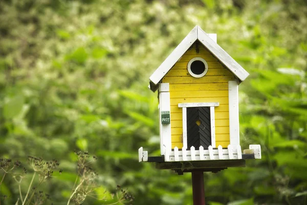 Κίτρινο birdhouse σε έναν κήπο — Φωτογραφία Αρχείου