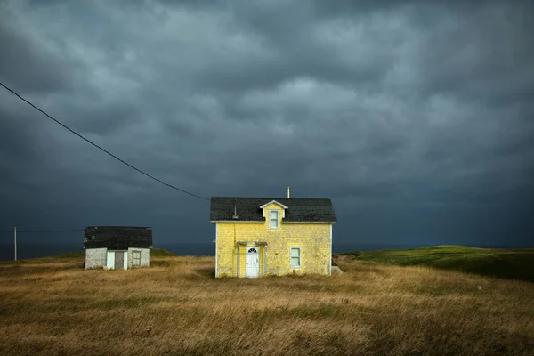 Bir koyu gri gökyüzü ile sarı ev — Stok fotoğraf