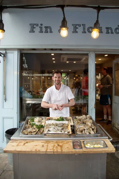 Un homme ouvre une huître fraîche chez lui à Londres — Photo