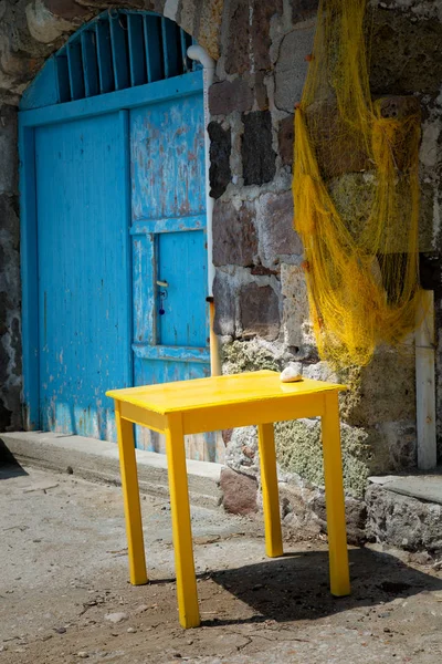 Gele tabel met blauwe deur — Stockfoto