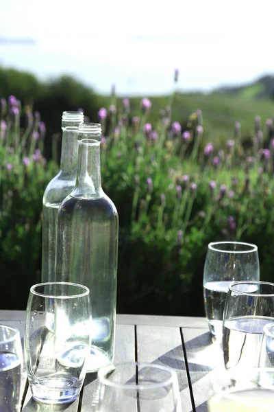 Lege flessen en glazen op de houten tafel — Stockfoto