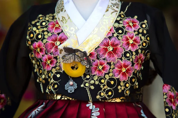 Flores cor de rosa bordadas em um vestido coreano tradicional — Fotografia de Stock