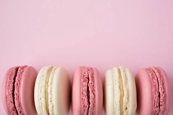 Row of white and pink macarons on pink — 스톡 사진