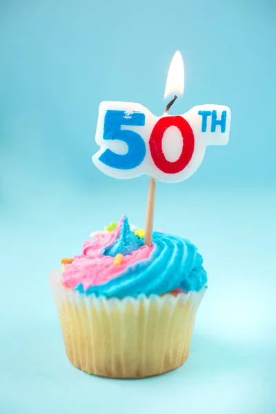 50th candle on a cupcake on a  blue background — Stock Photo, Image