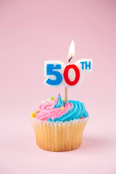 50ª vela sobre un cupcake sobre un fondo rosa — Foto de Stock