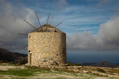 Yunanistan 'ın Naxos kentinde güzel bir yaz günü okyanus manzaralı bir tepenin üzerindeki yel değirmeninin güzel manzarası
