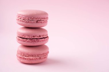 Pembe arka planda geleneksel Fransız makarnaları yığını