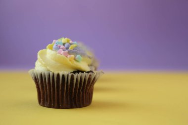  Paskalya sarısı ve mor arka planda şekerli eflatun çikolatalı kek.